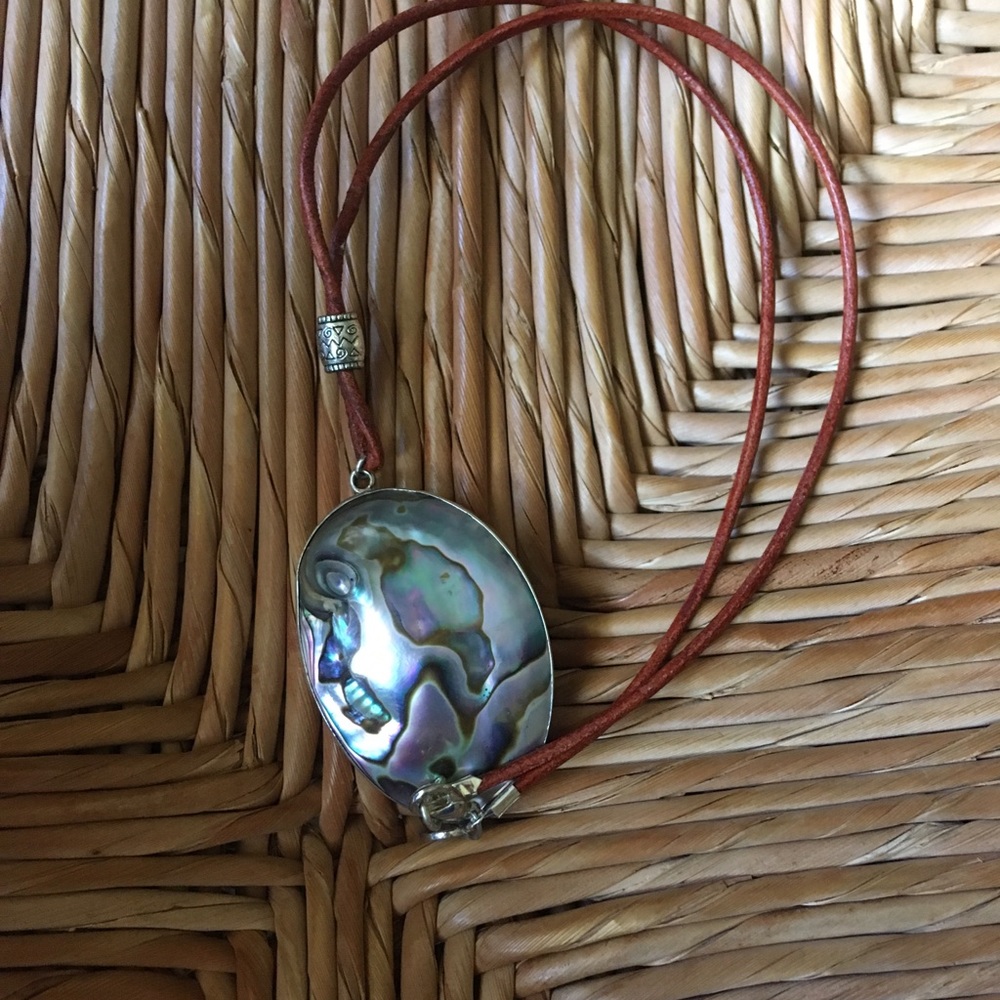 Mother of pearl with silver around/leather string